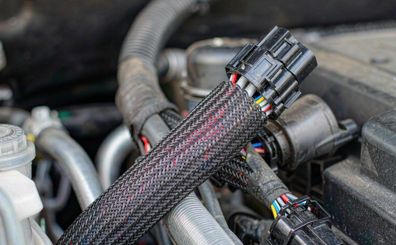 Automotive wire harness routes wrapped in PET braided sleeving and corrugated tube